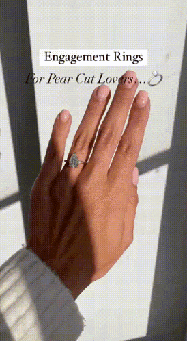 a woman 's hand with an engagement ring on her left hand
