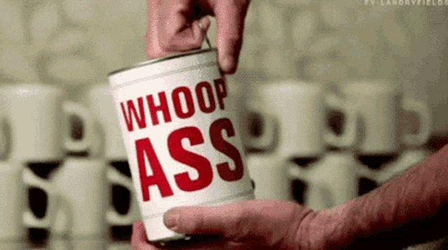 a man is opening a can of whoop ass