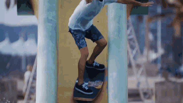 a man in shorts is riding a skateboard between two columns
