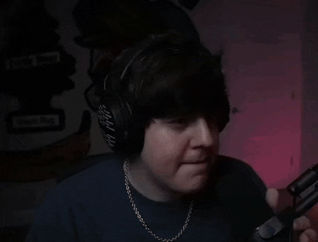 a close up of a man wearing headphones and making a funny face .