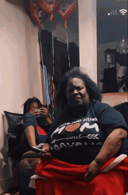 a woman wearing a shirt that says i have two titles mom and arrow