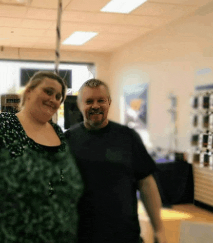 a man and a woman are posing for a picture in a blurry photo