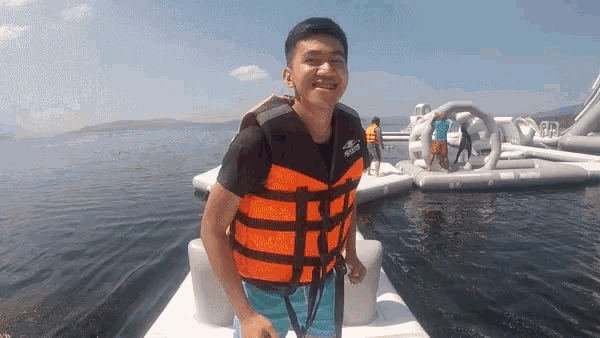 a man wearing an orange and black life jacket with the word rescue on it