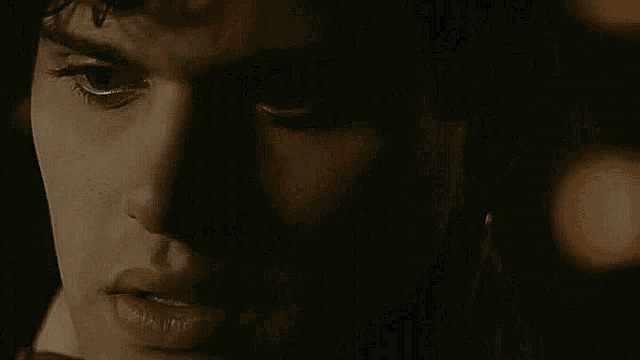 a close up of a man 's face in the dark with his mouth open .