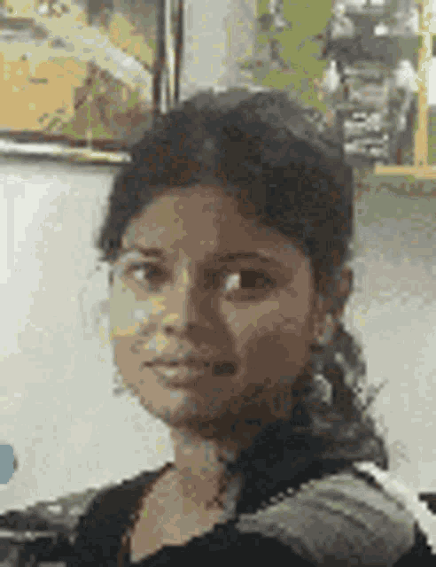 a close up of a woman 's face in front of a wall with a picture on it .