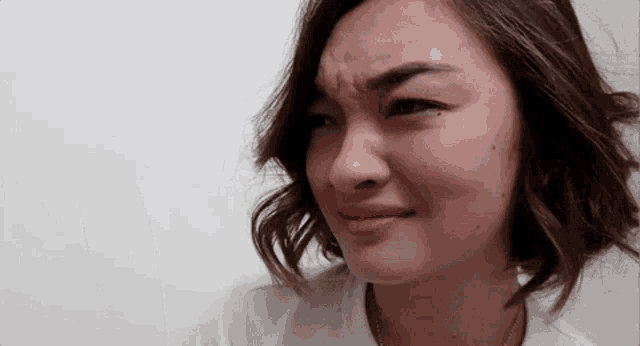 a close up of a woman making a funny face against a white background