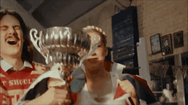 a man and a woman holding a trophy that says should
