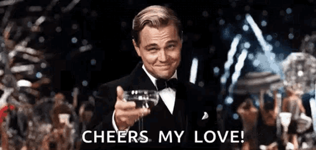 leonardo dicaprio is wearing a tuxedo and holding a glass of champagne at a party .