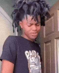 a young man with dreadlocks is wearing a paid in full t-shirt