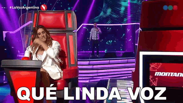 a woman sitting in a chair with the words que linda voz written on the screen