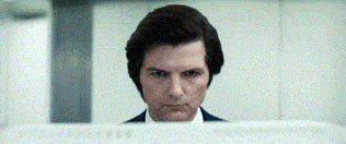 a man in a suit is looking at a monitor