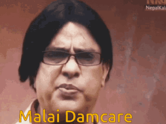 a man wearing glasses says malai damcare in yellow