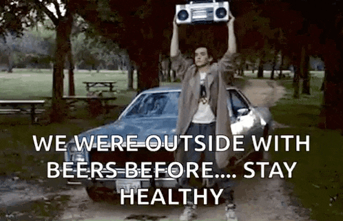 a man is standing in front of a car holding a boombox over his head .