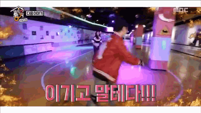 a man is riding a roller skate on a rink with korean writing on the screen