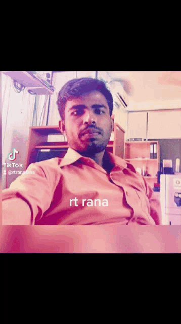 a man with a beard is sitting at a desk with a tik tok watermark on the bottom right