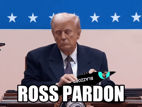 a man in a suit and tie is sitting at a desk with a sign that says ross pardon on it