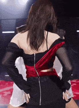 a woman in a black and red dress has a zipper on the back