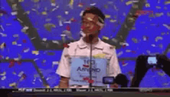 a boy stands in front of a microphone wearing a shirt that says 103 armo