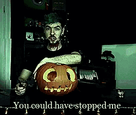 a man is holding a pumpkin with a face carved into it