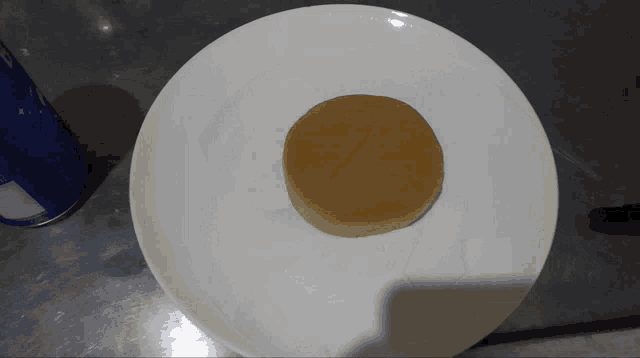 a white plate with a small brown item on it