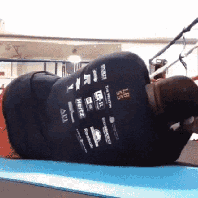 a man is laying on a blue mat wearing a shirt that says 55 lbs