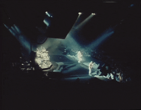 a group of people standing on a stage with lights shining on them