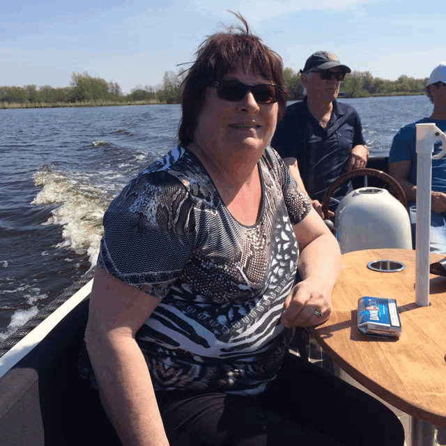 a woman sitting on a boat with a pack of cigarettes next to her