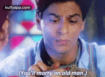 a man is holding a ring in his hand and saying `` you 'll marry an old man '' .