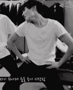 a man in a white shirt is standing with his hands on his hips