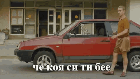 a man standing next to a red car with the words " che koja si ti bee " written on the bottom