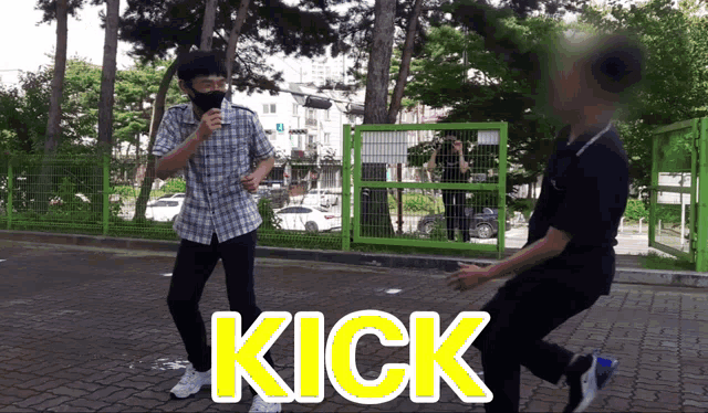 a man wearing a mask is standing next to another man who is kicking him