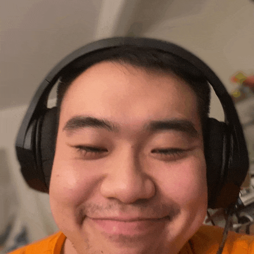 a man wearing headphones looks at the camera and smiles