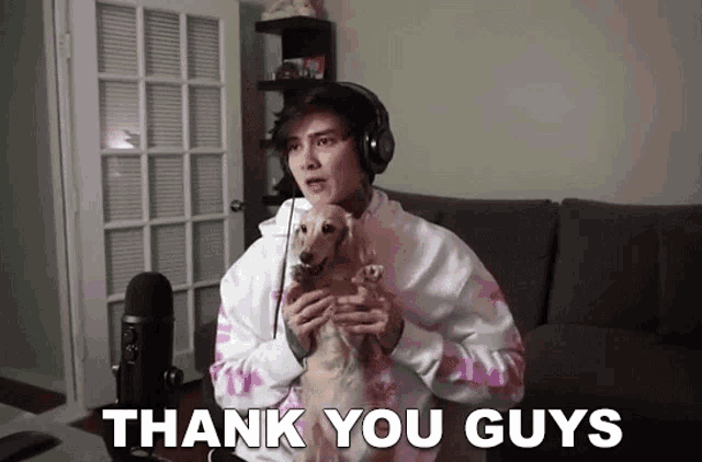a man is holding a dog in his arms and says thank you guys