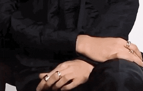 a close up of a person 's hands wearing rings .