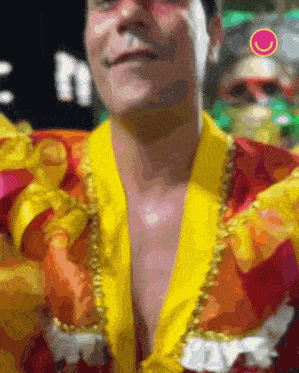 a man in a yellow and red costume has a smiley face on his shoulder