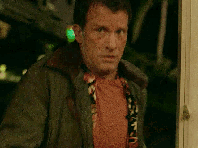 a man in a green jacket with the word fuck written on it
