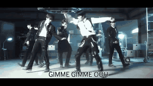 a group of men are dancing with the words gimme gimme ooh in the background