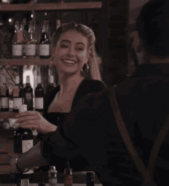 a woman is holding a bottle of wine with a label that says ' wine '