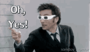 a man in a suit and tie wearing 3d glasses is pointing at something and says oh yes .