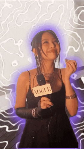 a woman in a black dress is holding a microphone and smiling .