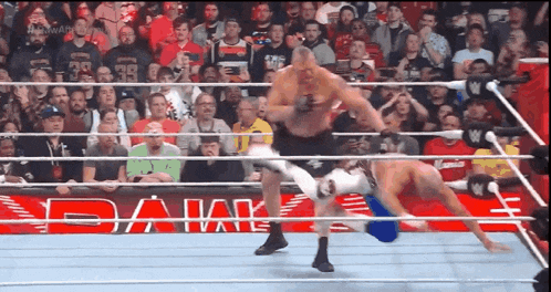 a wrestling match is going on in front of a crowd with the word bank on the side