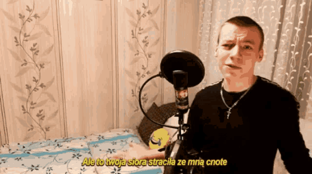 a man stands in front of a microphone with the words ale to twoja siora stracha ze mnie cnote written below him
