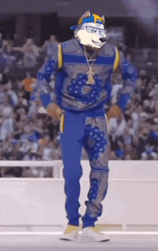 a man with a wolf mask on his head dancing in front of a crowd