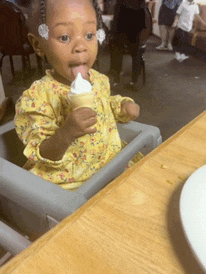 a little girl is eating an ice cream cone
