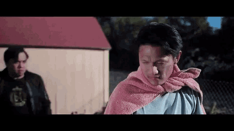 a man with a pink towel around his neck .