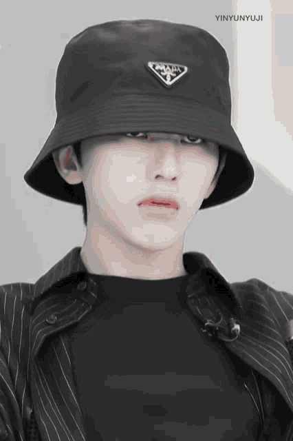 a man wearing a black hat with a prada logo