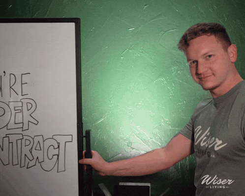 a man standing in front of a white board that says ' i 're der utract '