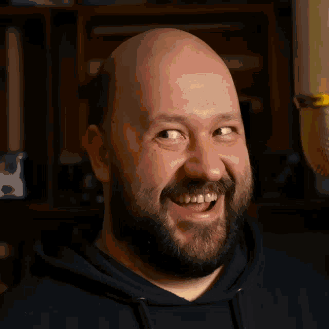 a man with a beard is smiling with his mouth open