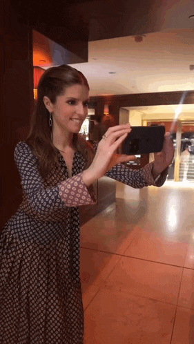 a woman is taking a picture of herself with her cell phone