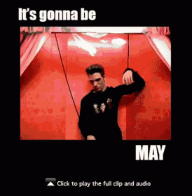 a man is dancing in front of a red curtain with the words it 's gonna be may on the bottom